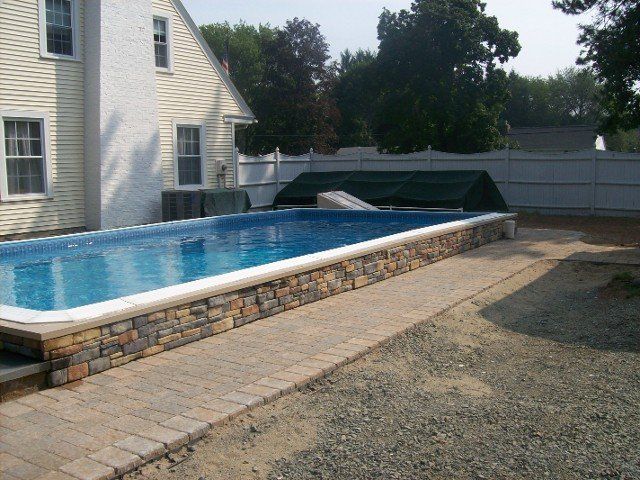 Back yard brick walkway with stone retainer wall for the pool - back yard landscaping services - Stellato Bros. Inc. in Feeding Hills, MA