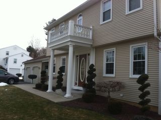 Front yard landscaping with shrubs and paved walkway - landscaping services - Stellato Bros Inc in Feeding Hills, MA