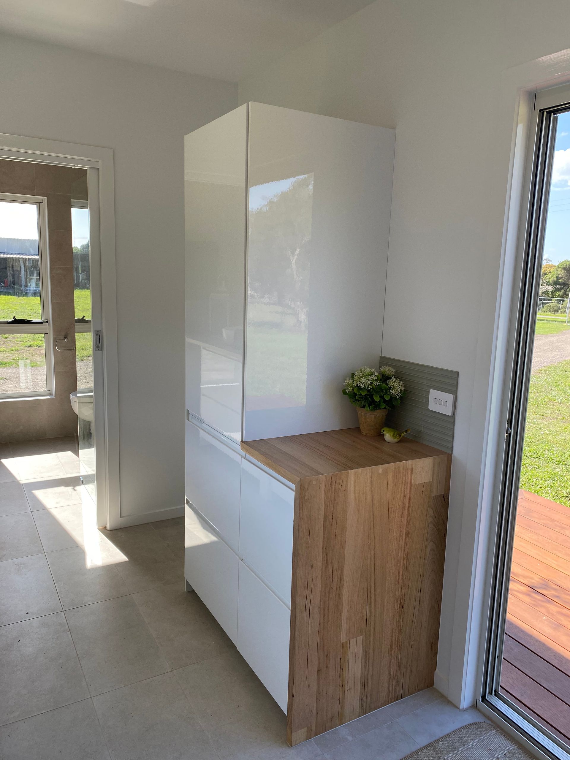Kitchen With White Cabinets And A Wooden Counter Top In Tiny House — GTH Living In Geelong, VIC