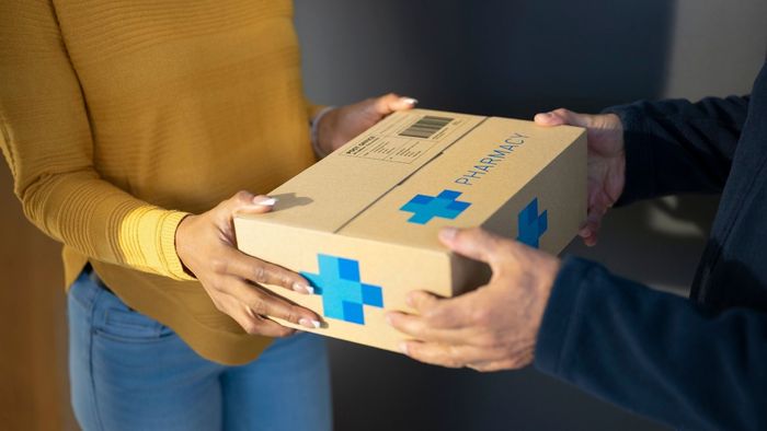A man is handing a box to a woman.