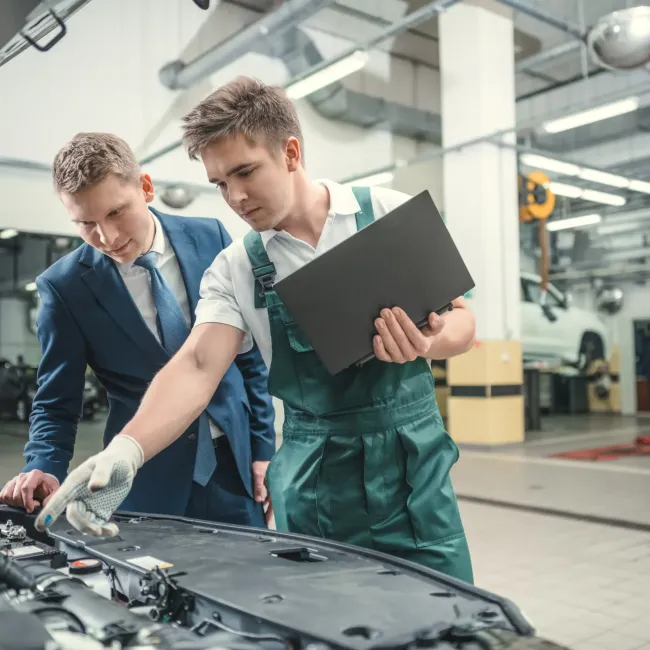 Old Faithful Company LLC - Two men are working on a car in a garage.