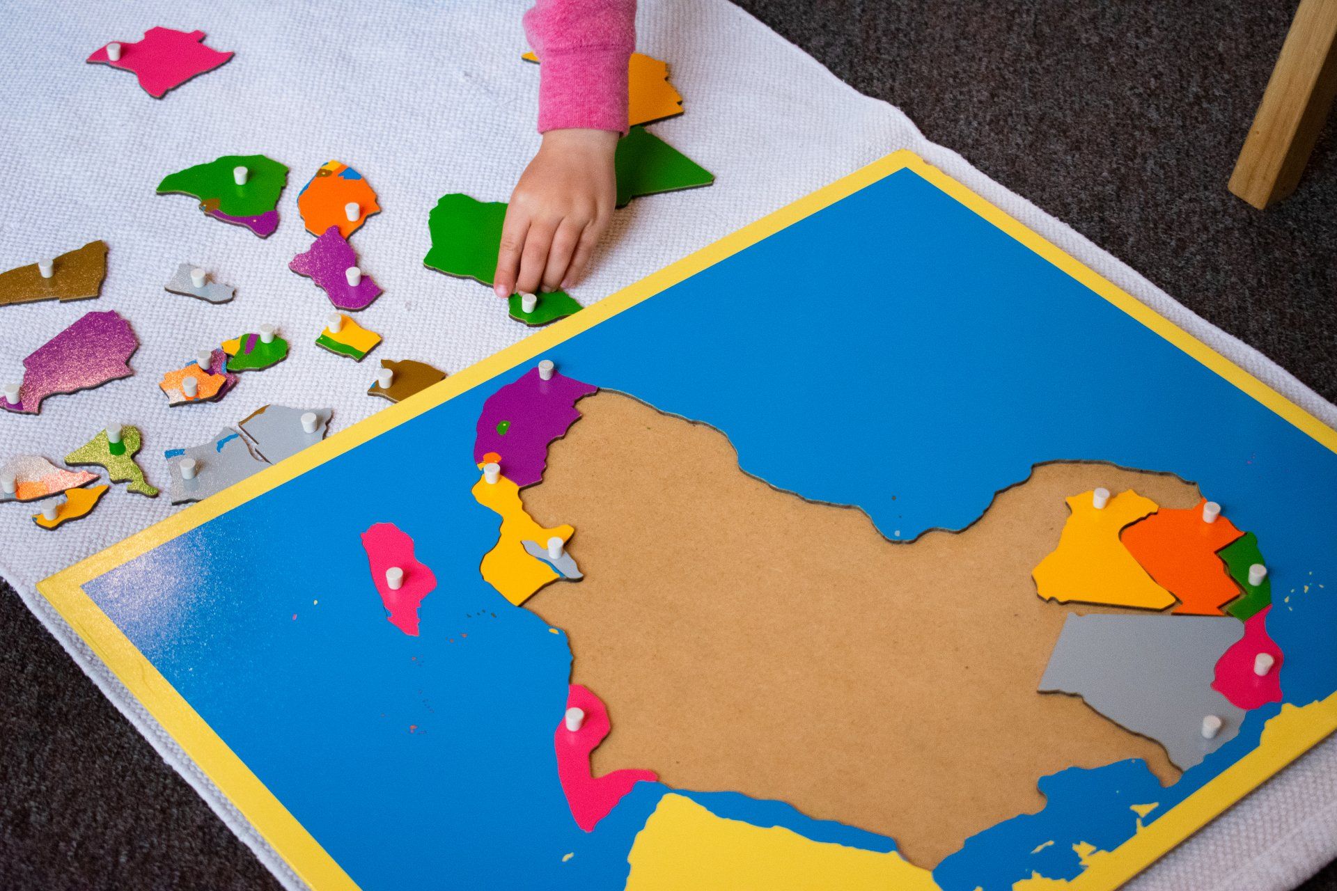 A Montessori child is working with a map