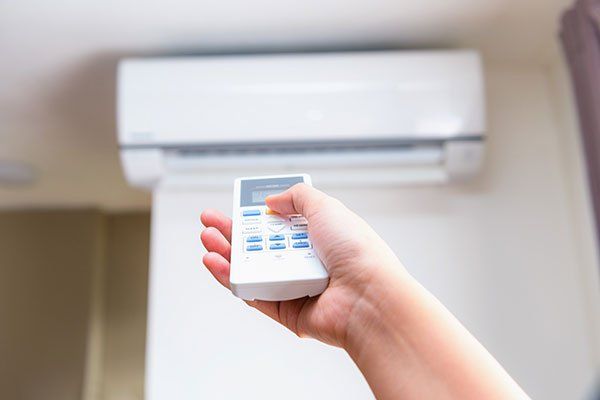 AC Installation — Hand Operating Air Conditioner Remote Control in Talent, OR