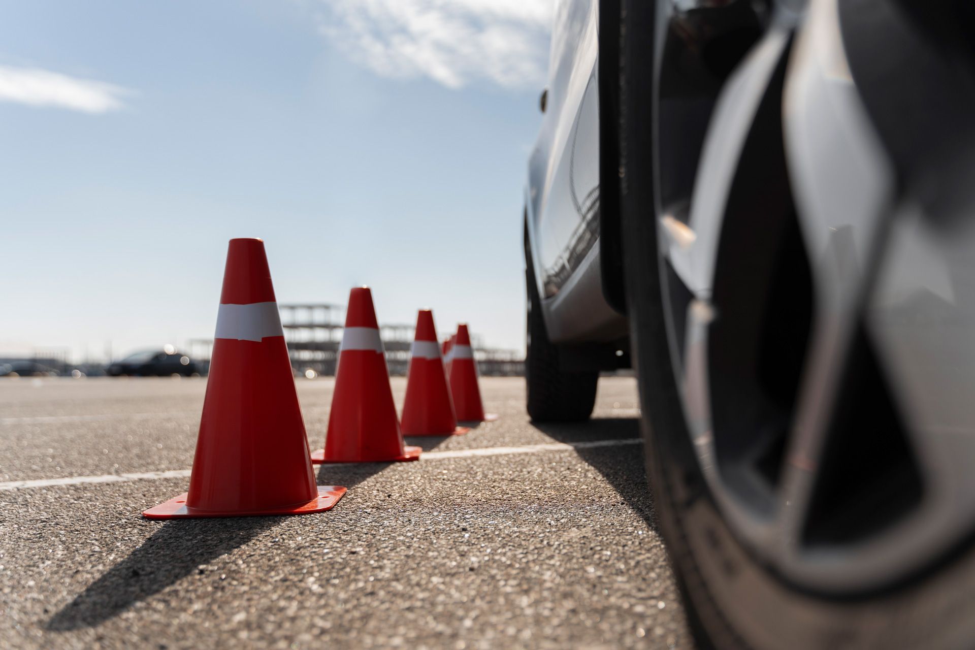 A row of orange traffic cones beside a car in a parking lot in Houston, Texas.