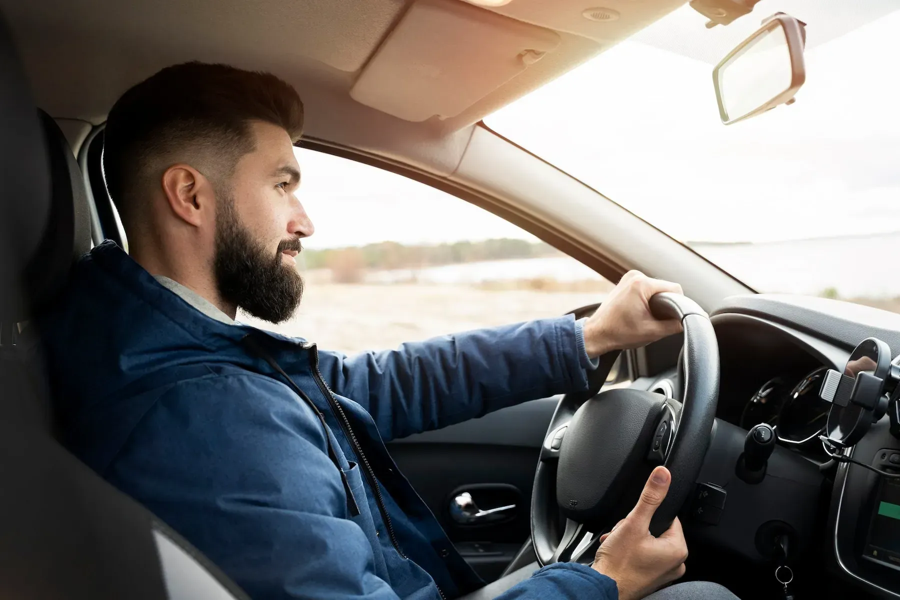 Man driving a car, focusing on the road ahead.