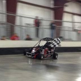 A person is driving a go kart on a track.