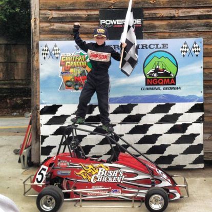 A man stands on top of a bush 's chicken go kart