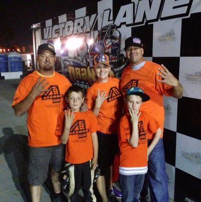 A group of people standing in front of a sign that says victory lane
