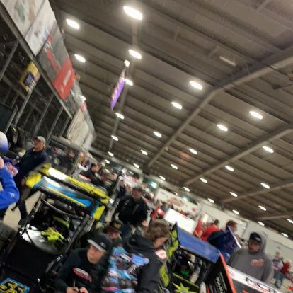 A group of people are standing in a large room.