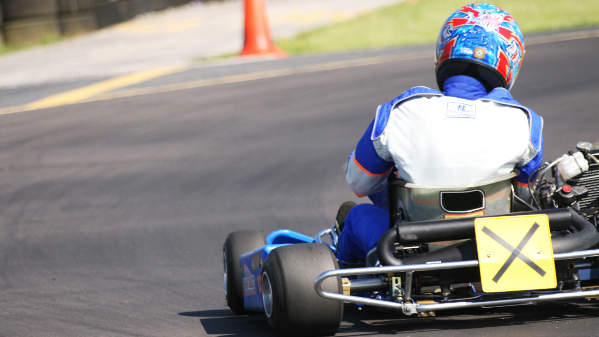 A person is riding a go kart on a track.