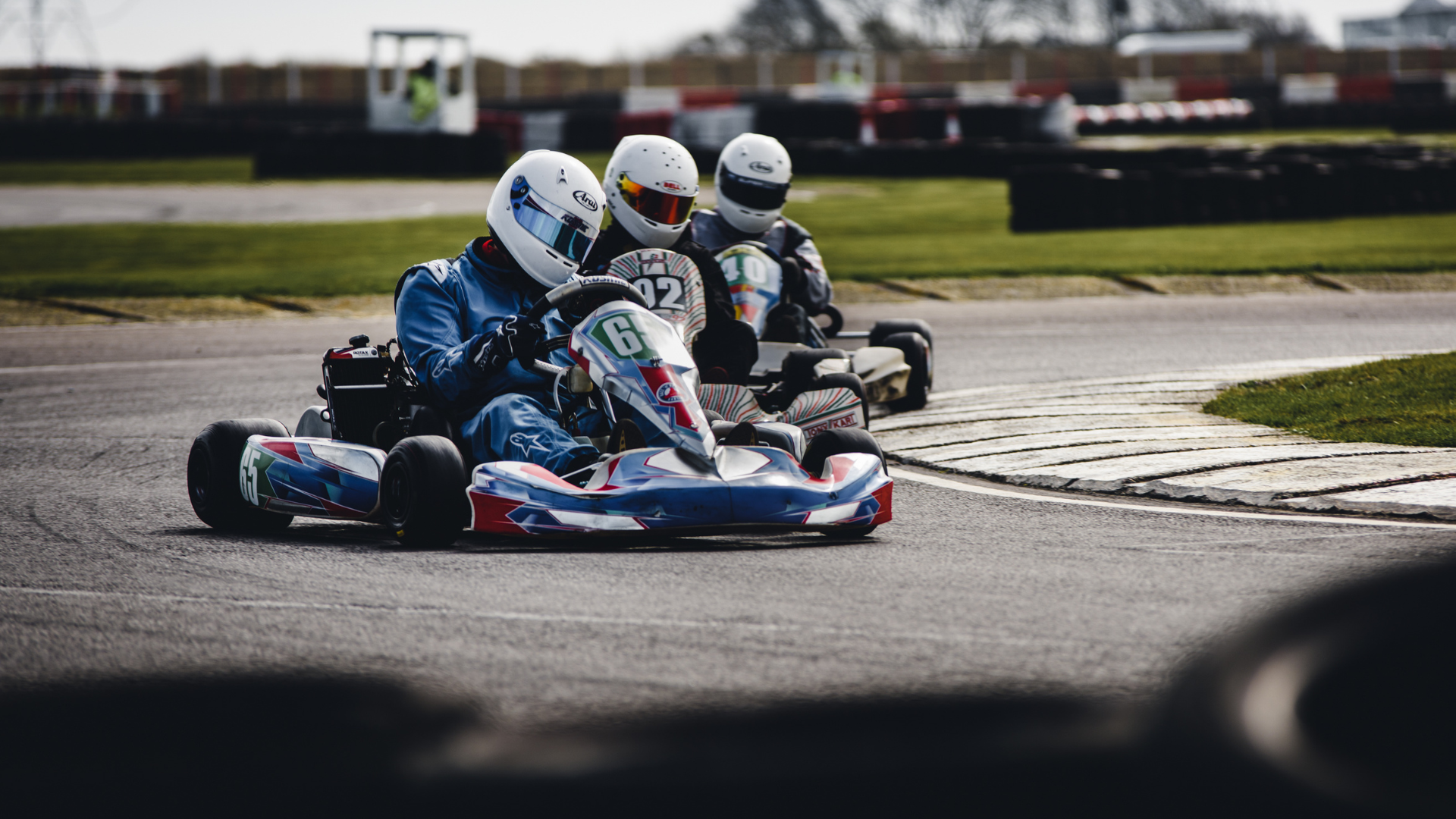 A group of people are riding go karts on a track.