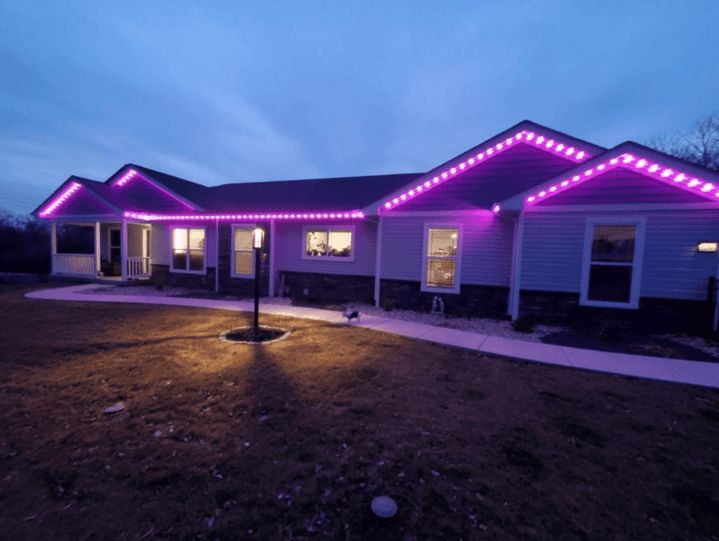 House with purple roofline lights at dusk.