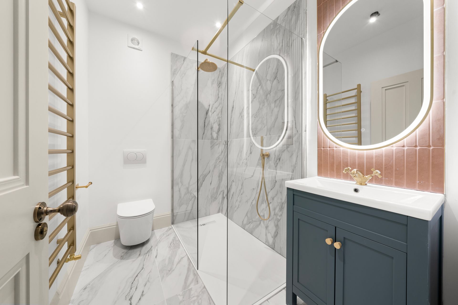 A bathroom with a walk in shower , sink , toilet and mirror.