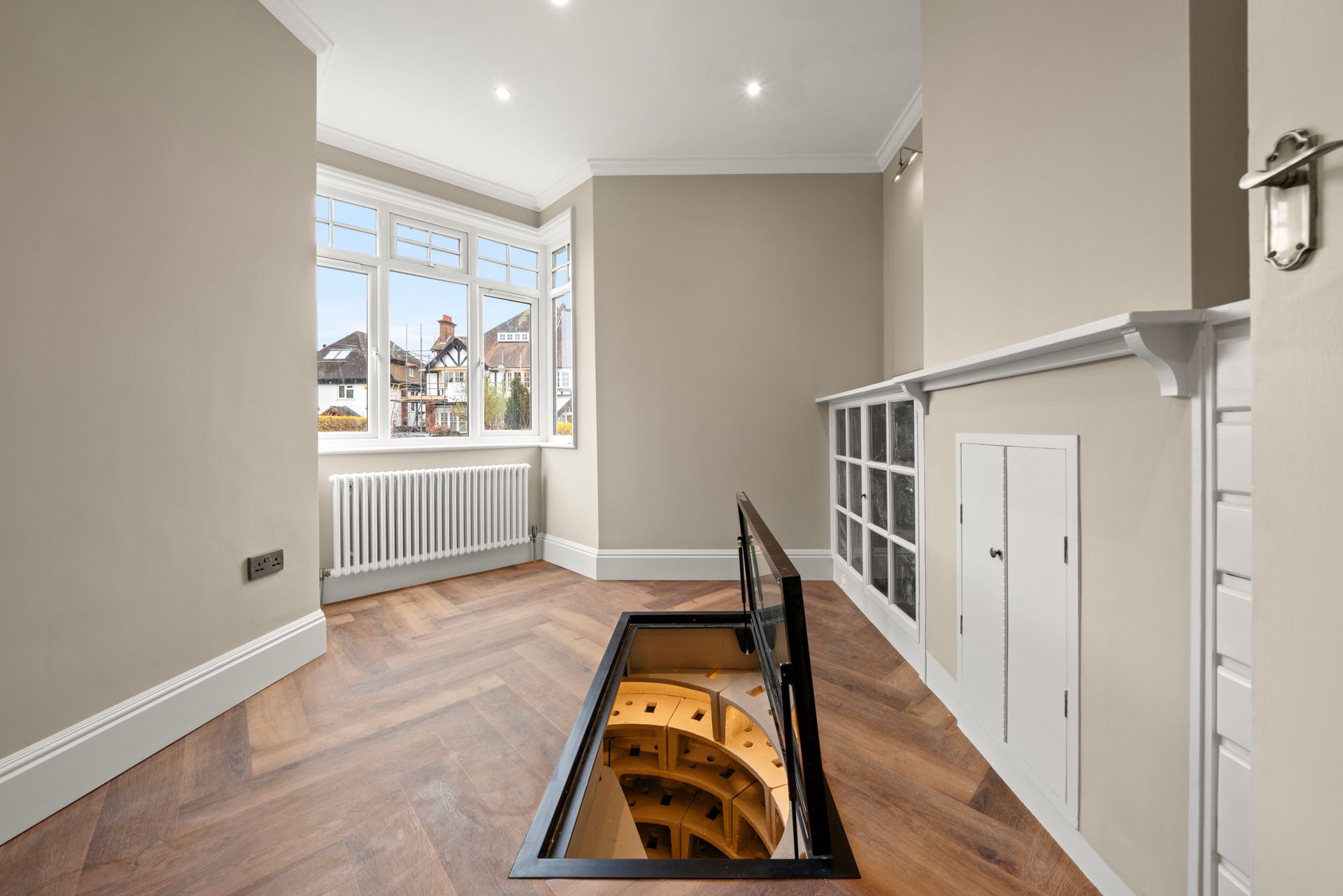 An empty room with a spiral staircase leading up to the second floor.