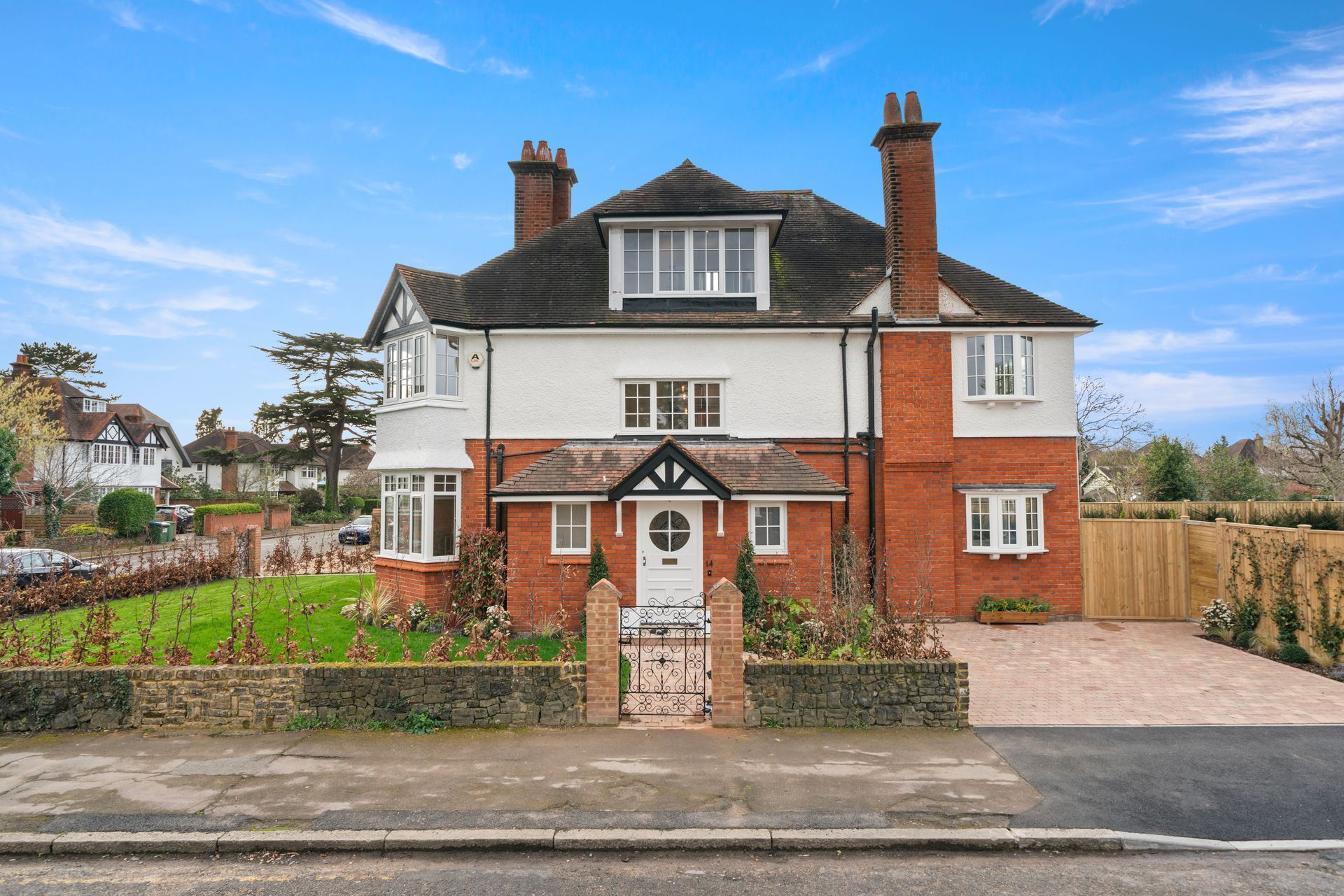 A large red and white brick house with a driveway in front of it.