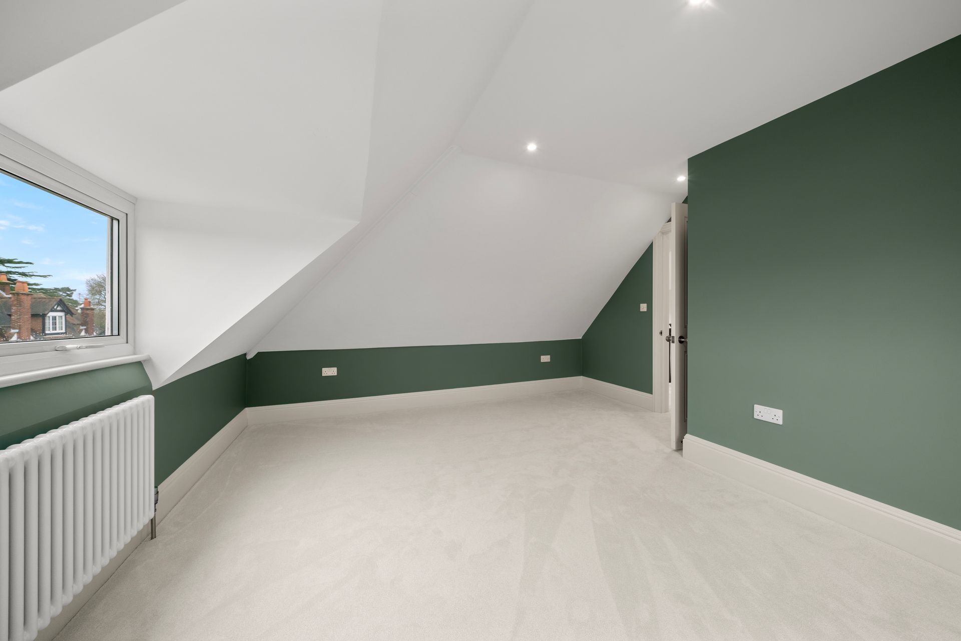 An empty room with green walls and white carpet