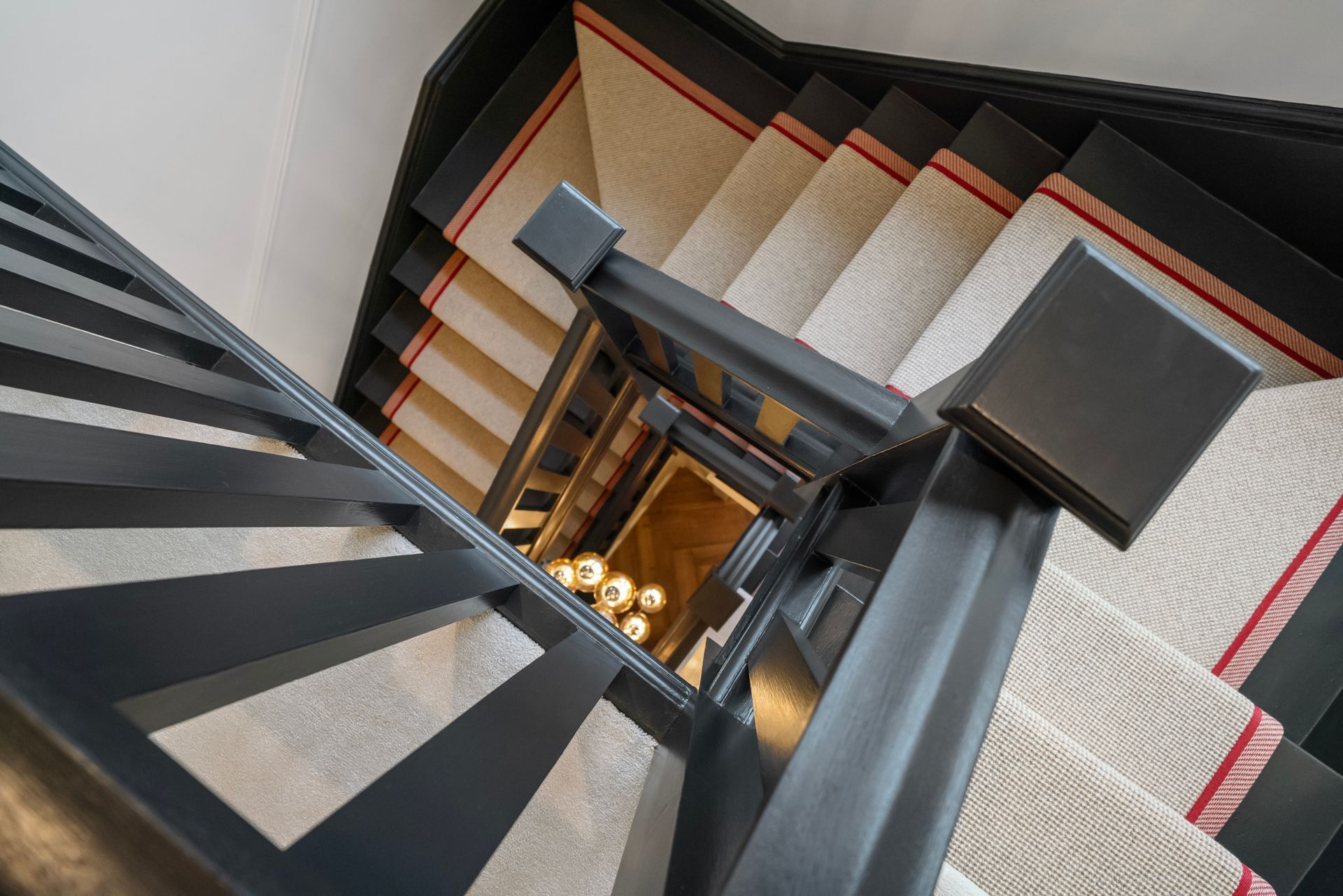 A staircase with a carpeted staircase and a black railing