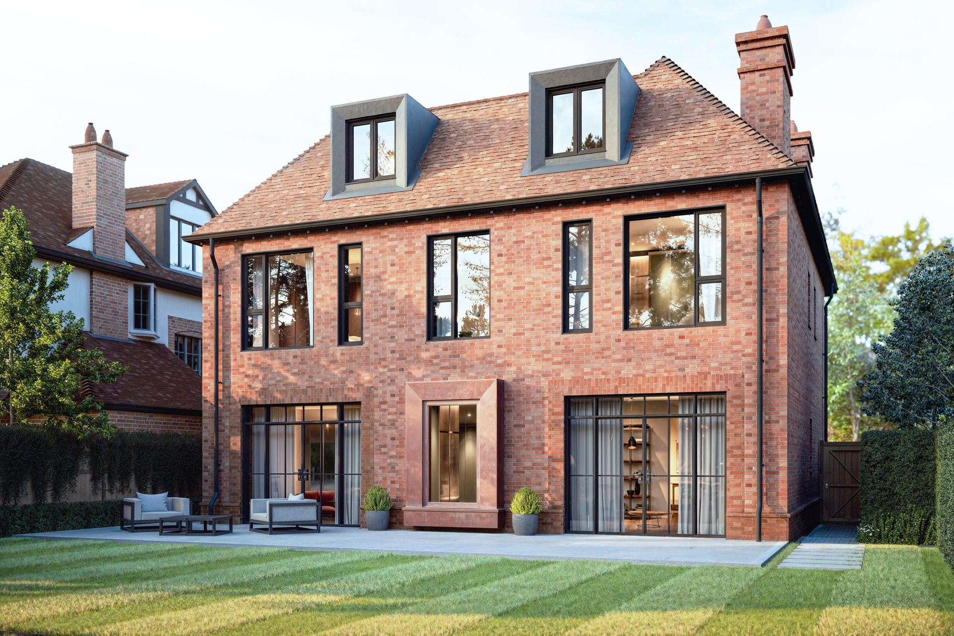A large brick house with a lot of windows and a lawn in front of it.