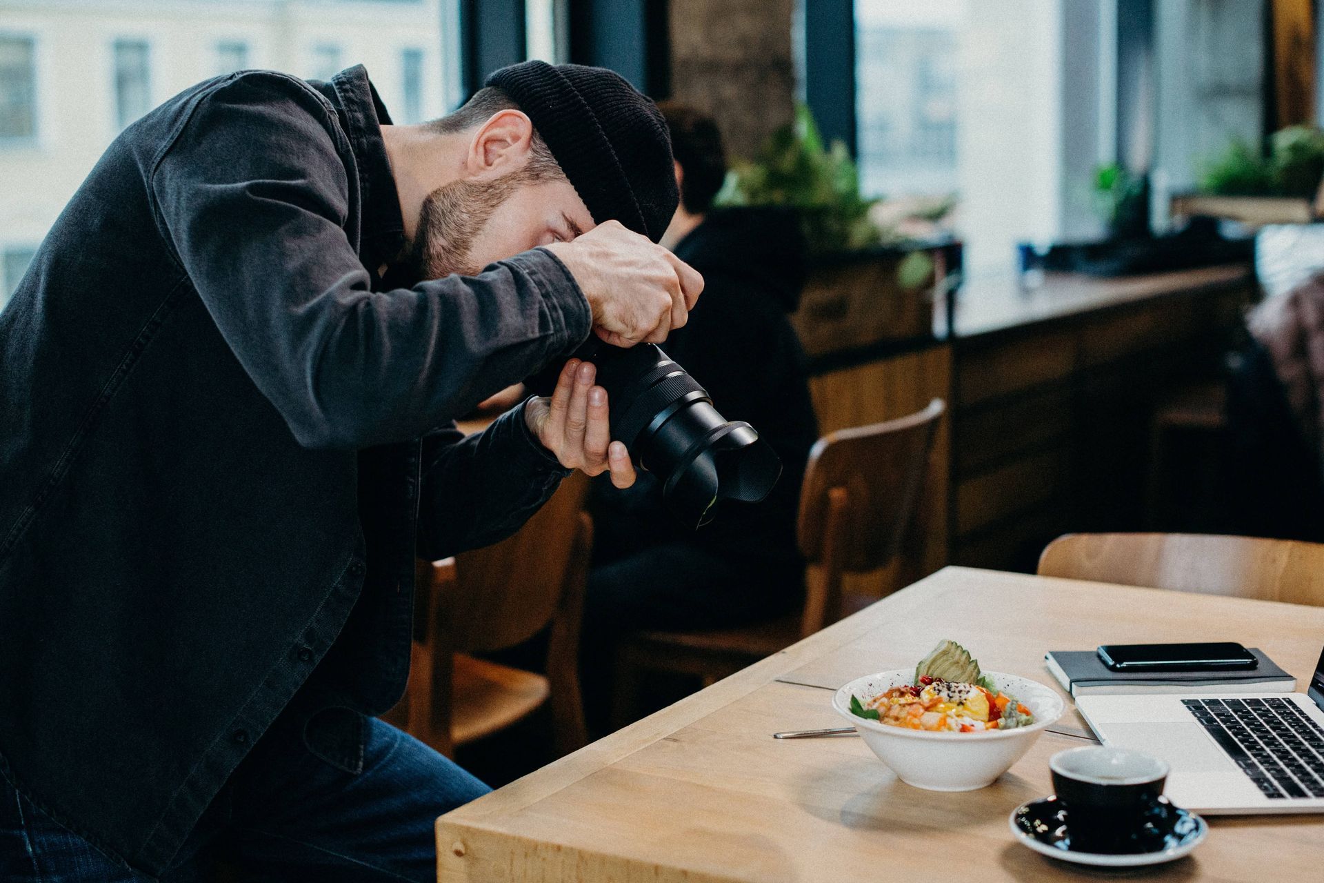 Fotógrafo tomando fotografía a un producto en una mesa de madera