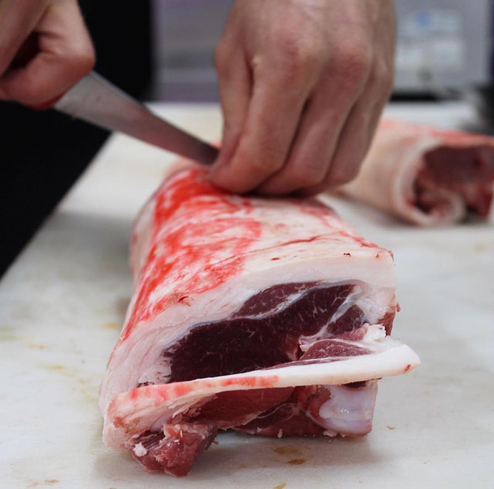 A Person is Cutting a Piece of Meat on a Cutting Board — Nambour Heights Butchery in Nambour, QLD