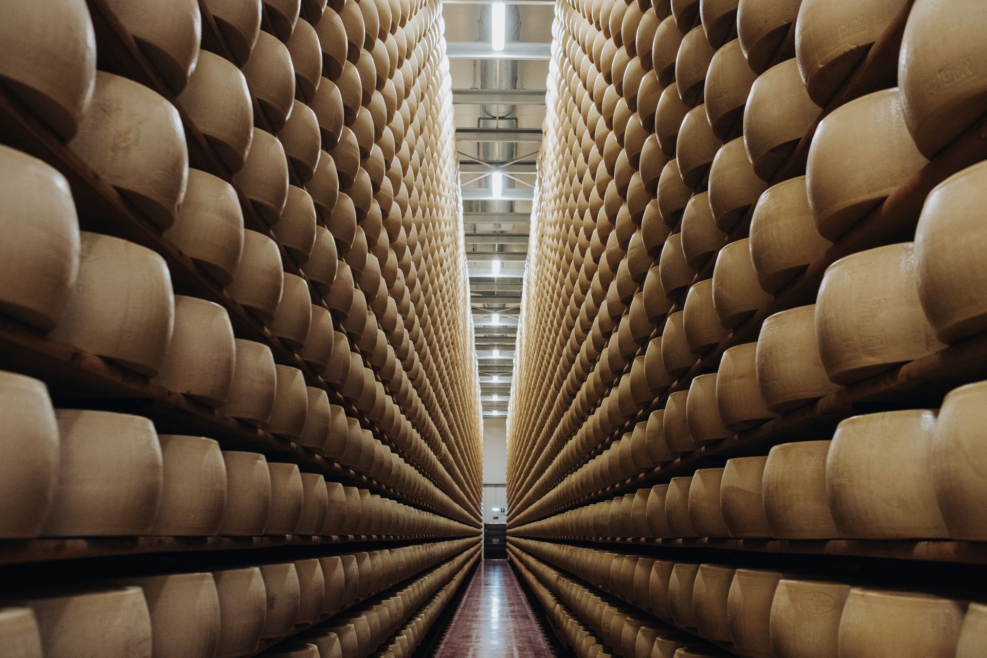 Assortimento di formaggi italiani, salumi, miele, vino e spumante rosé disposti su uno sfondo neutro.