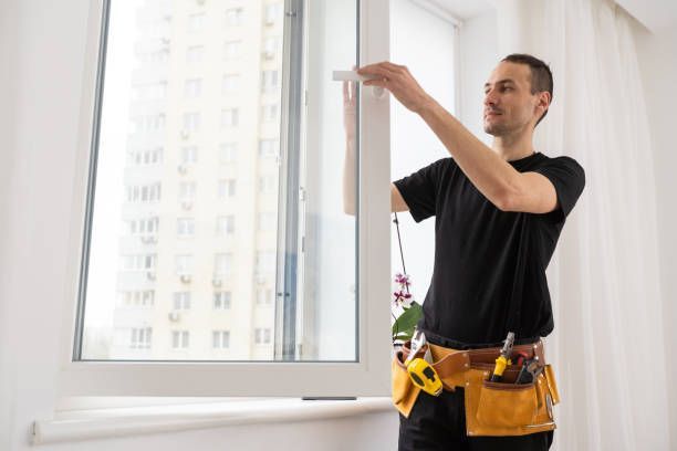 A man is installing a window in a room.