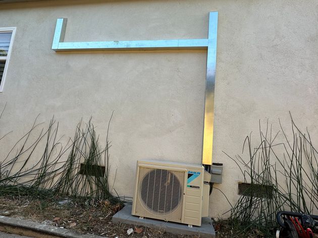 A daikin air conditioner is mounted on the side of a building