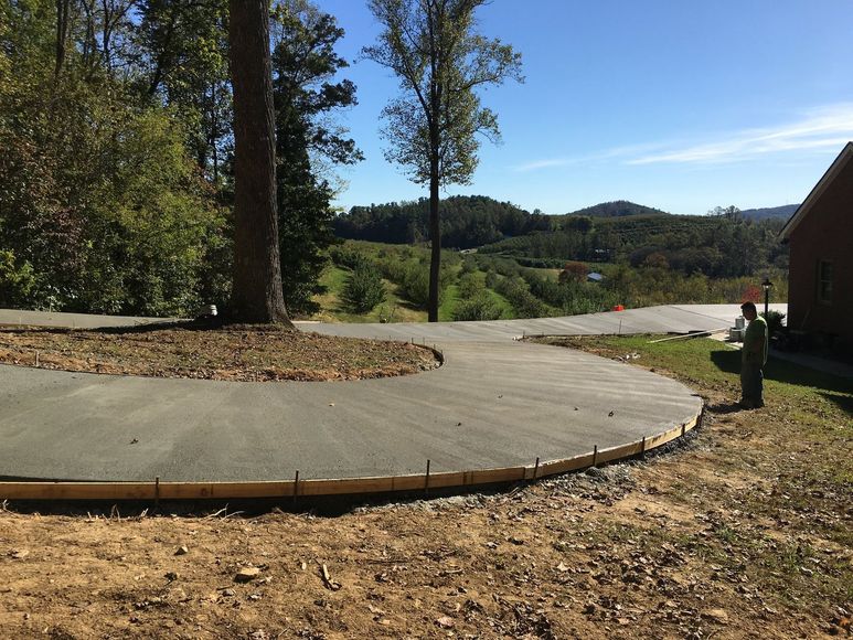 A concrete walkway is being built in front of a house