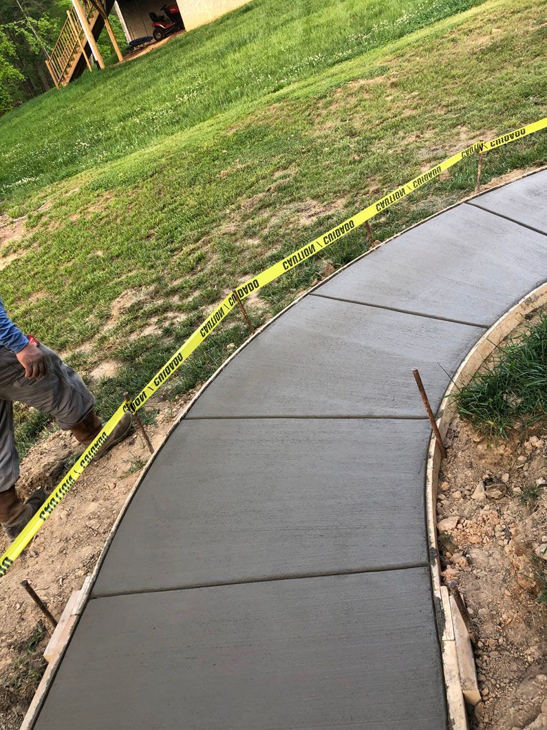 A man is walking down a curved concrete walkway.