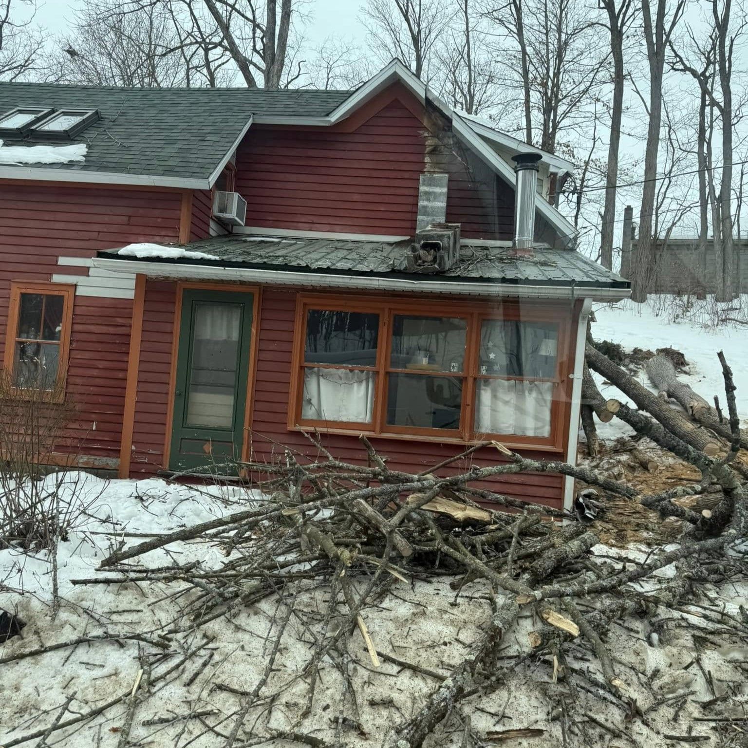 A red house is surrounded by snow and branches. A red house is surrounded by snow and branches.