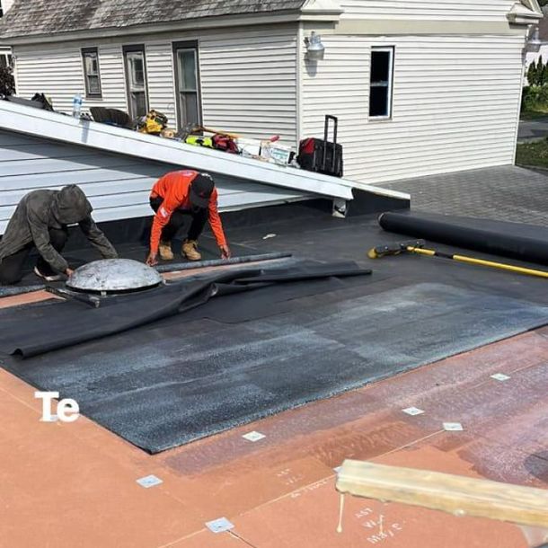 A man is working on the roof of a house. A man is working on the roof of a house.