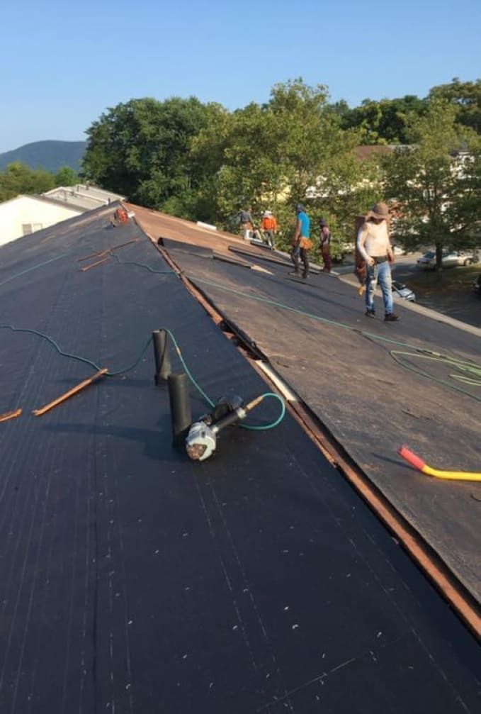 A group of people are working on a roof.