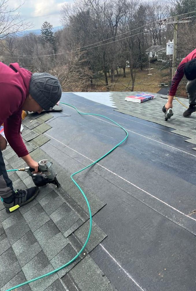 A couple of men are working on a roof.