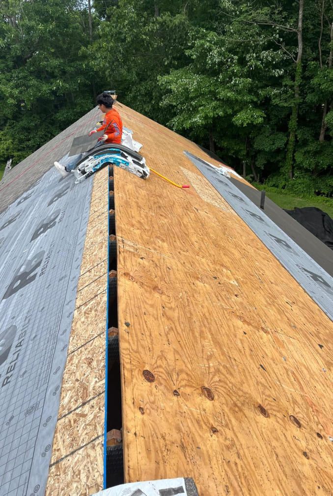 A man is working on the roof of a house.
