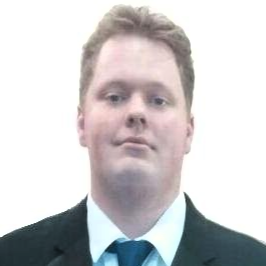 Man in suit and tie looking at the camera. He has fair skin and light brown hair.