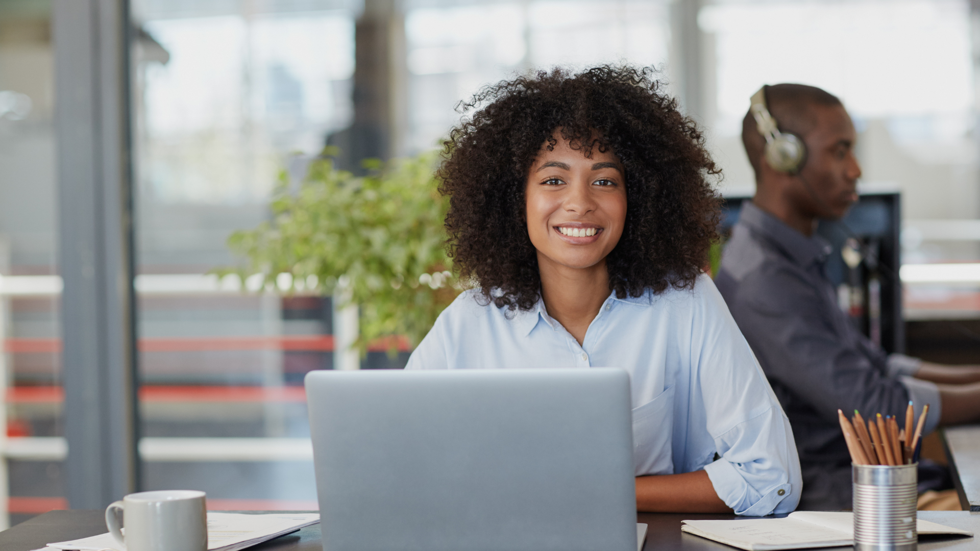 Une femme est assise à un bureau devant un ordinateur portable.