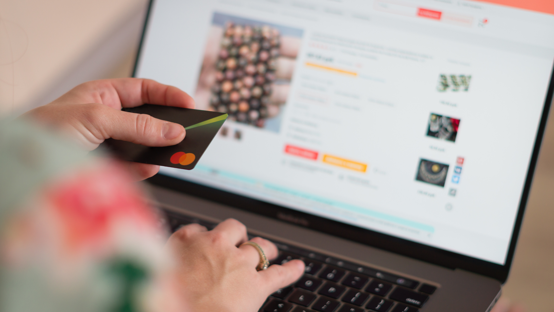 Person shopping online, holding credit card, using laptop.