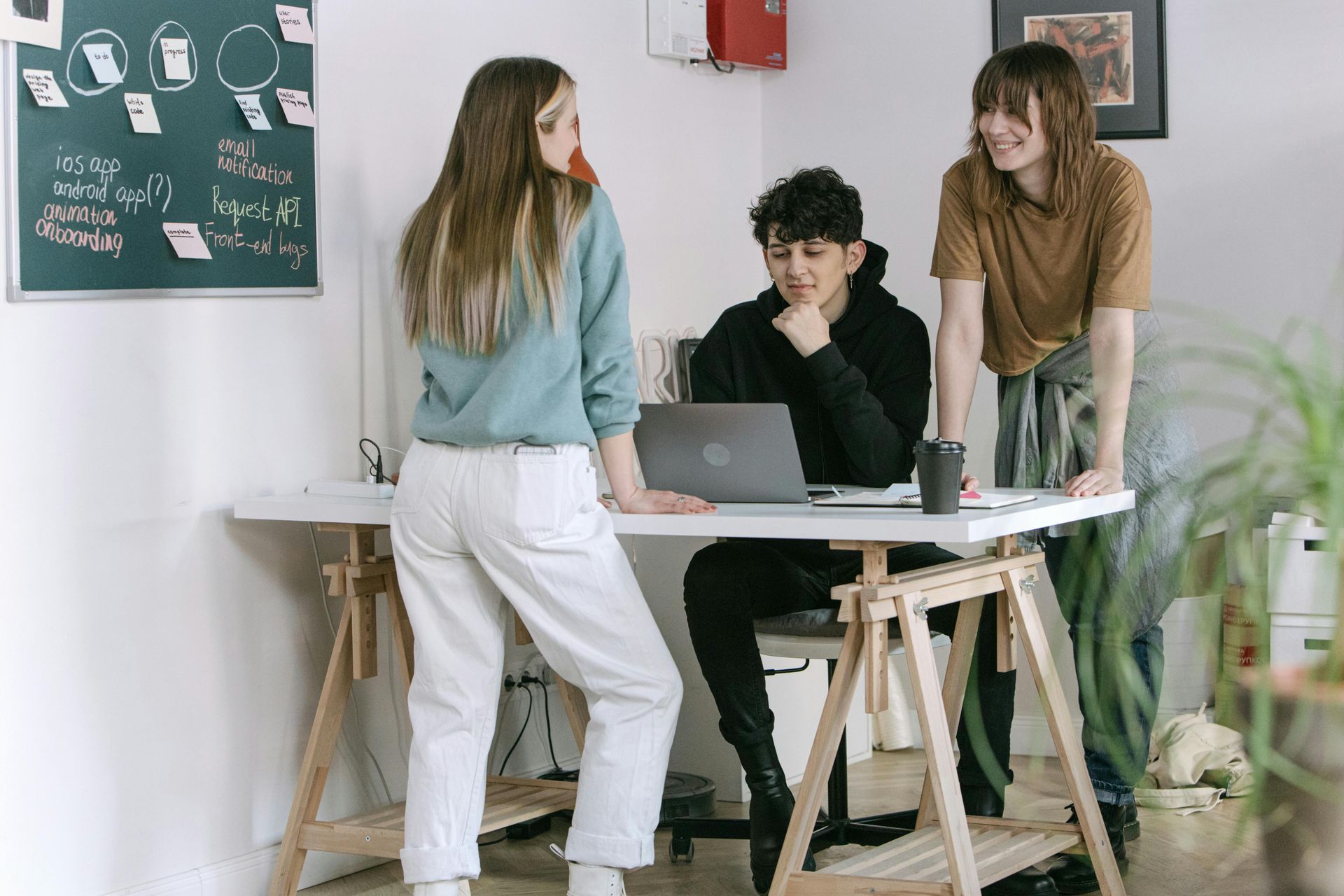 Un groupe de personnes se tient autour d'une table avec un ordinateur portable.
