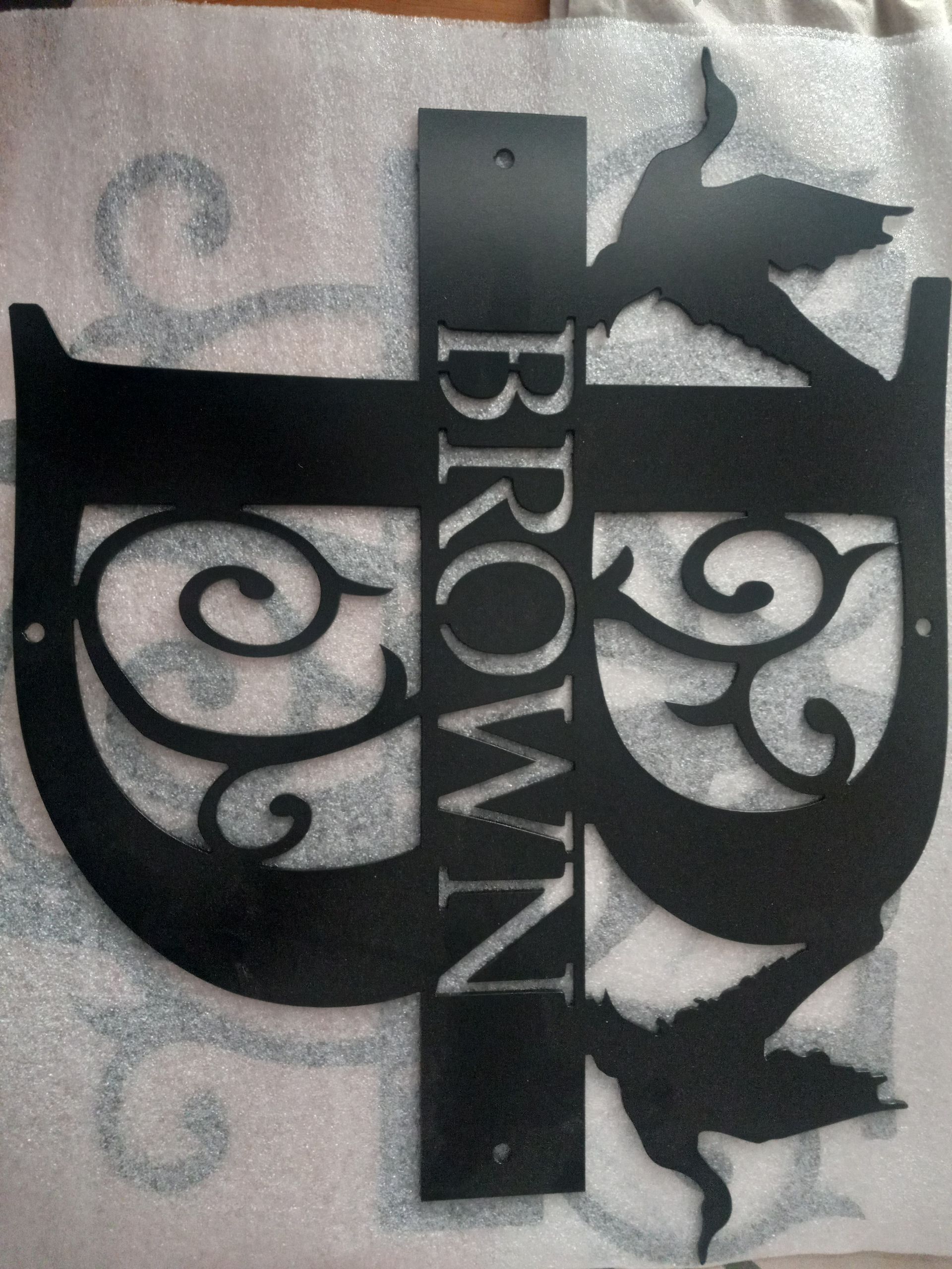 Black metal sign with the name 