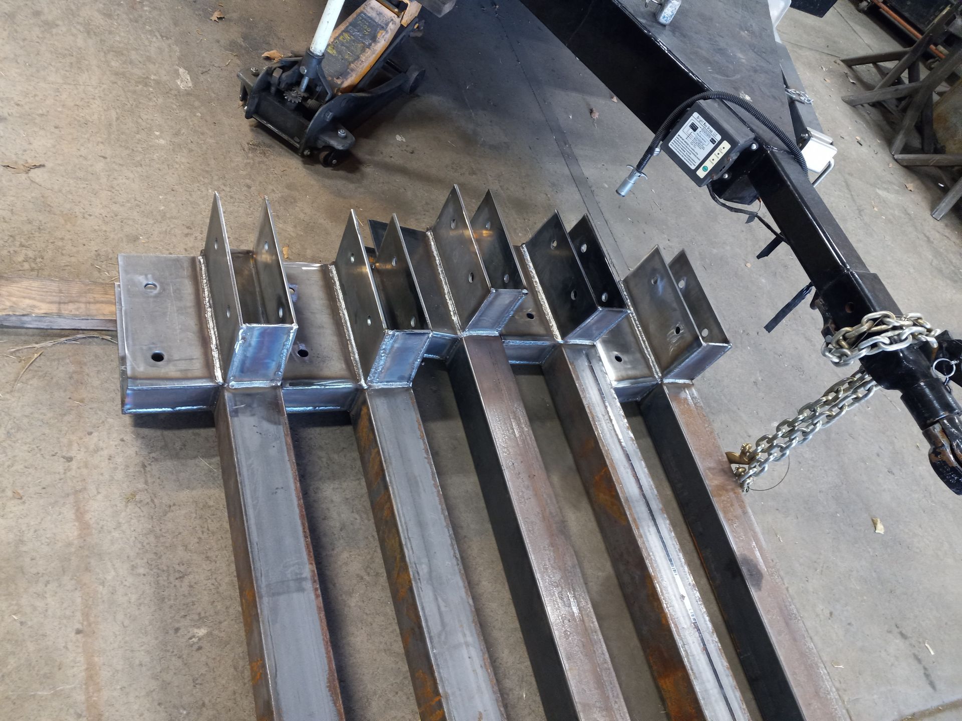 Construction worker with safety harness installing metal frame of a building.