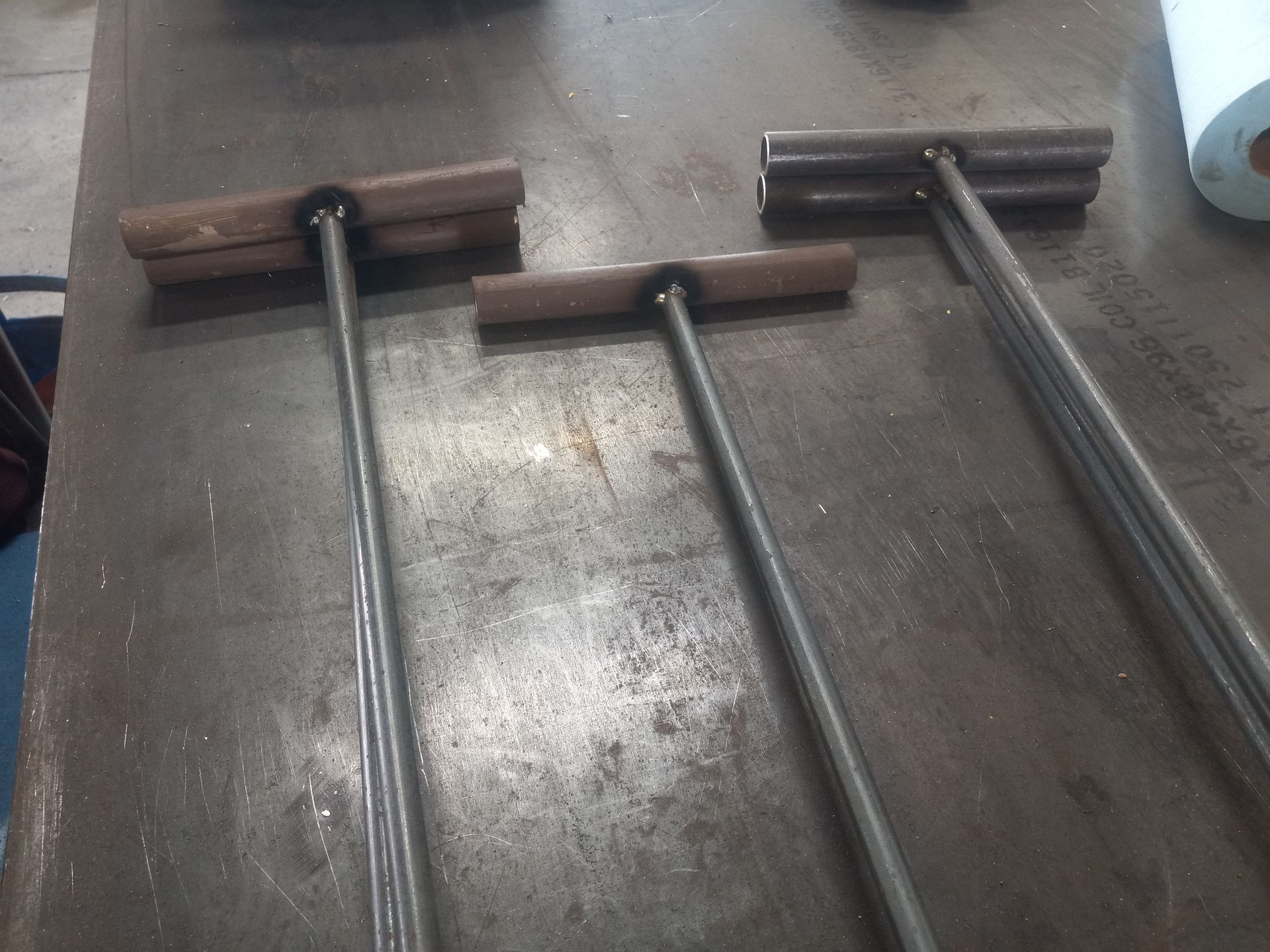 Three metal tools with wooden handles on a metal surface.