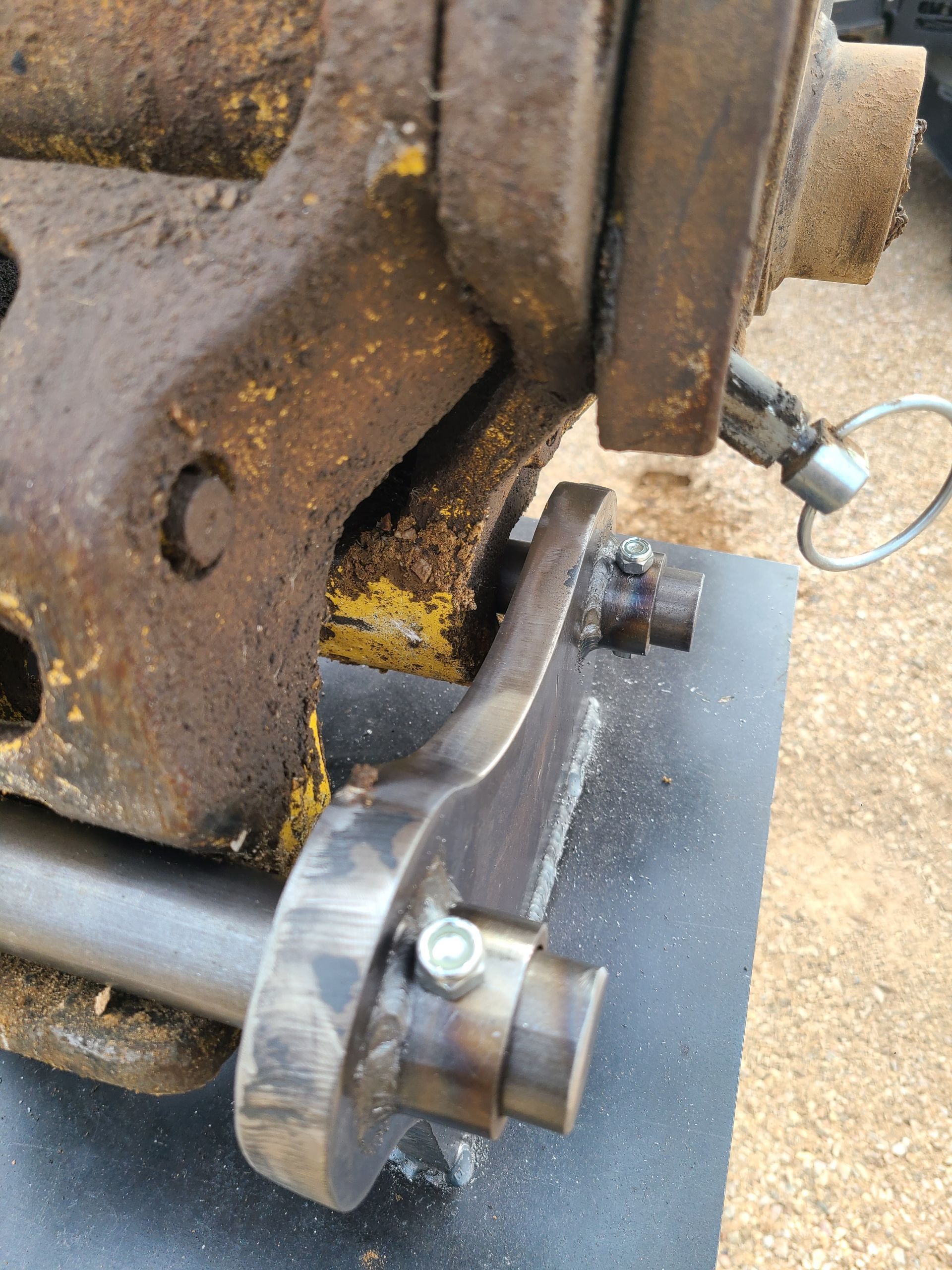 Close-up of a rusty metal machine part with a silver bolt and pin.