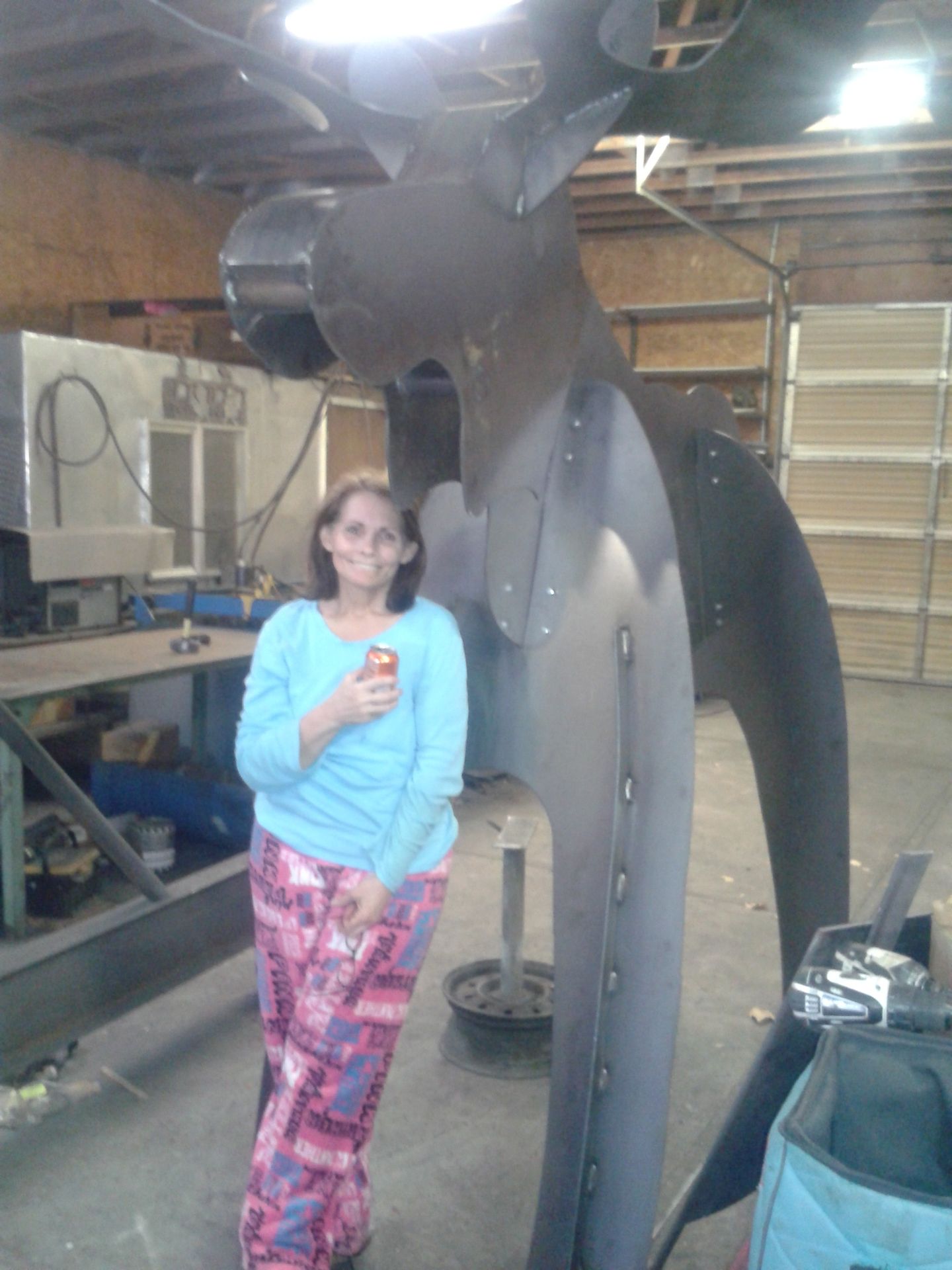Metal flower sculptures in a vase. Gray and bronze tones, in an indoor setting.