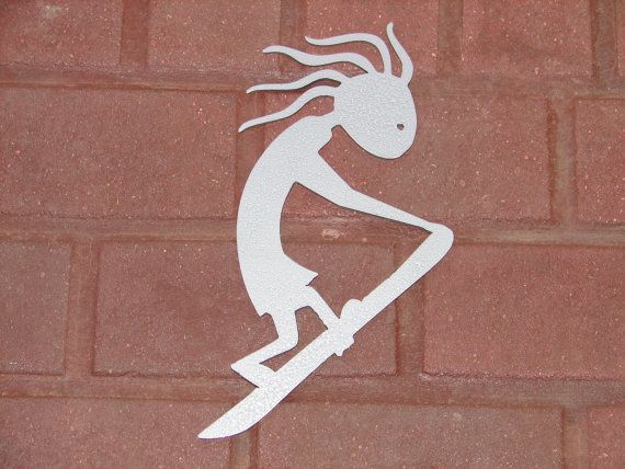 White silhouette of a Kokopelli surfing on a board against a red brick background.