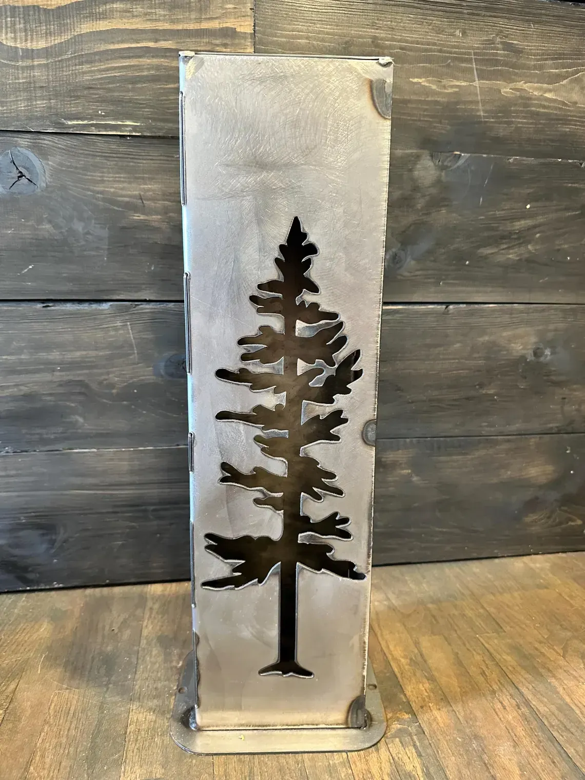 Metal flower sculptures in a vase. Gray and bronze tones, in an indoor setting.