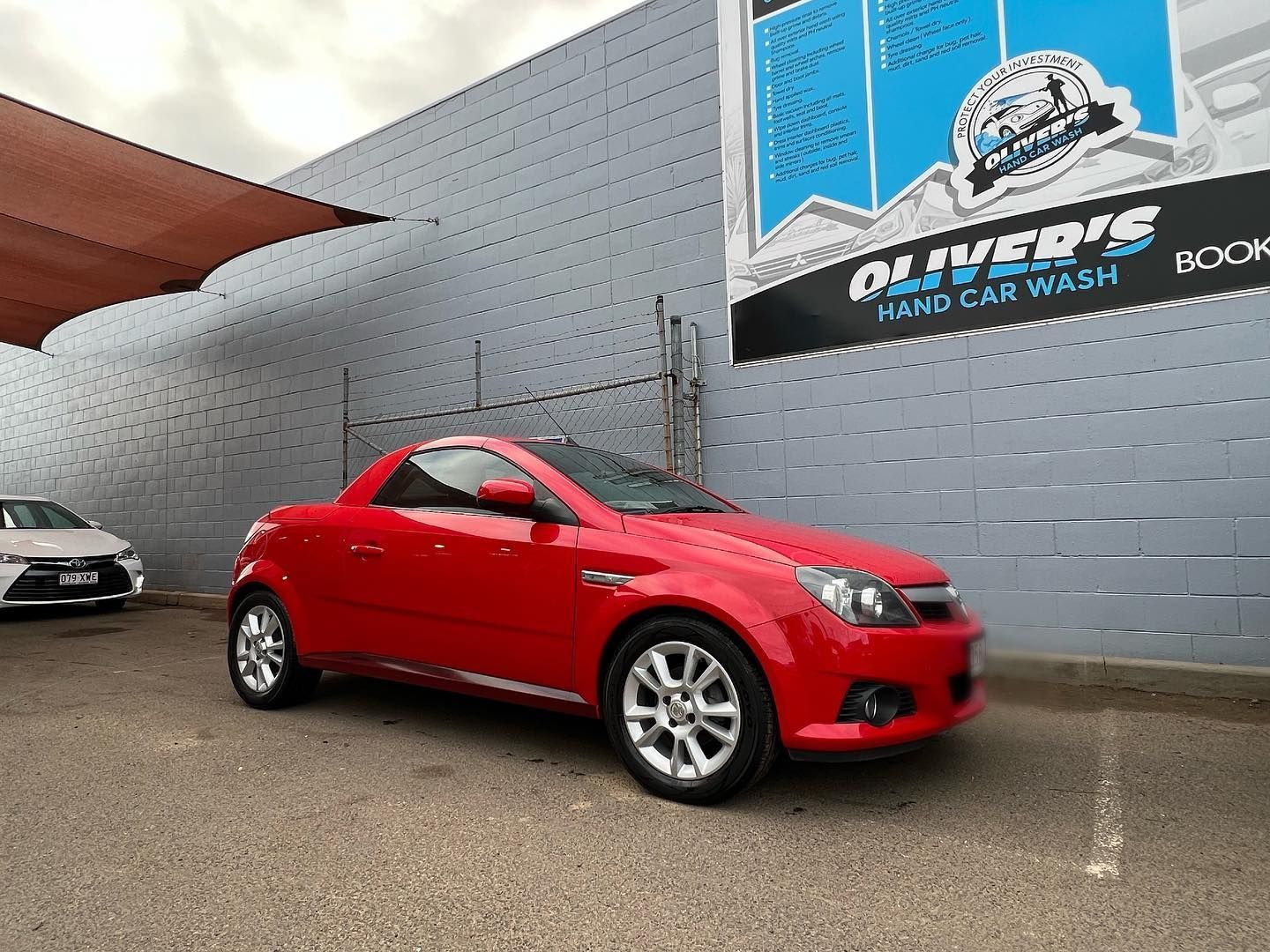 Red convertible car parked outside Oliver's Hand Car Wash. — Oliver's Hand Car Wash in Norville, QLD