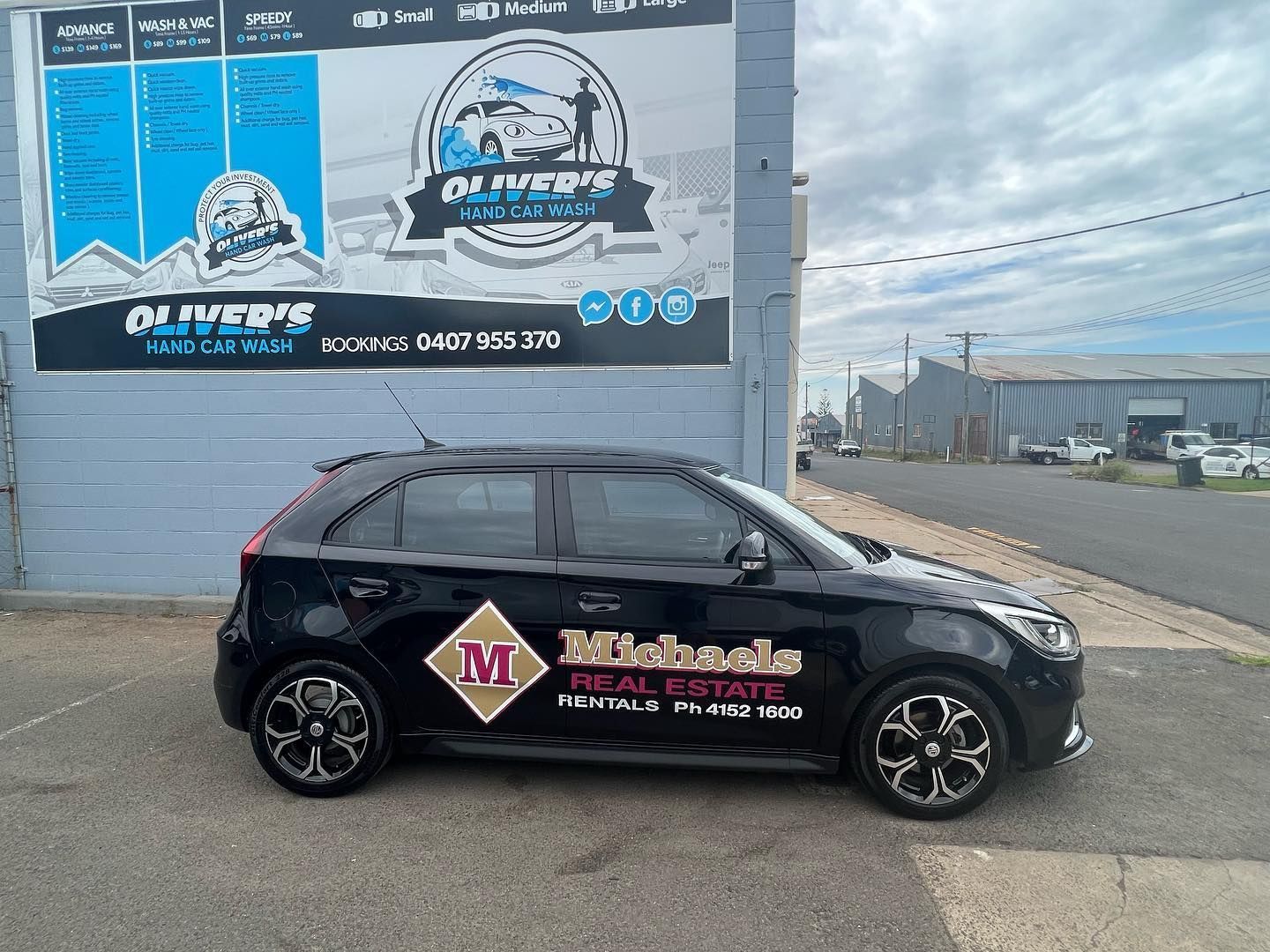Black car with real estate branding parked in front of a building. — Oliver's Hand Car Wash in Norville, QLD