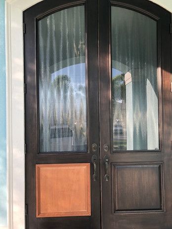 A close up of a door with a wooden trim and a glass door.