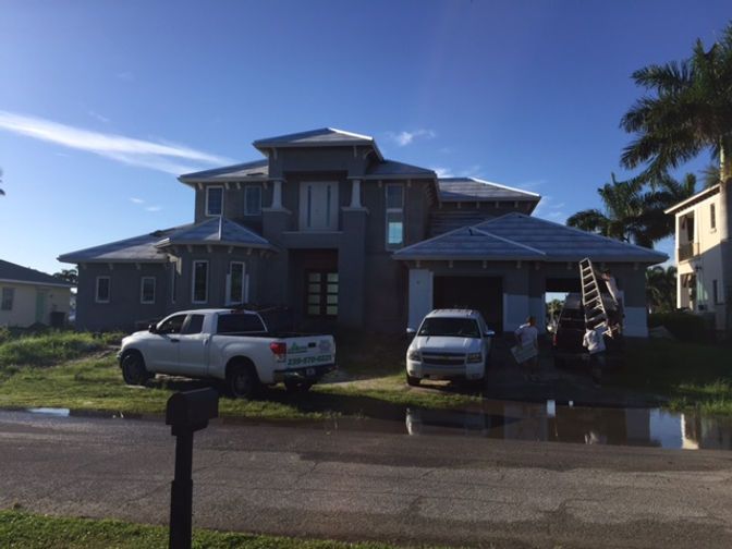 A white truck is parked in front of a large house