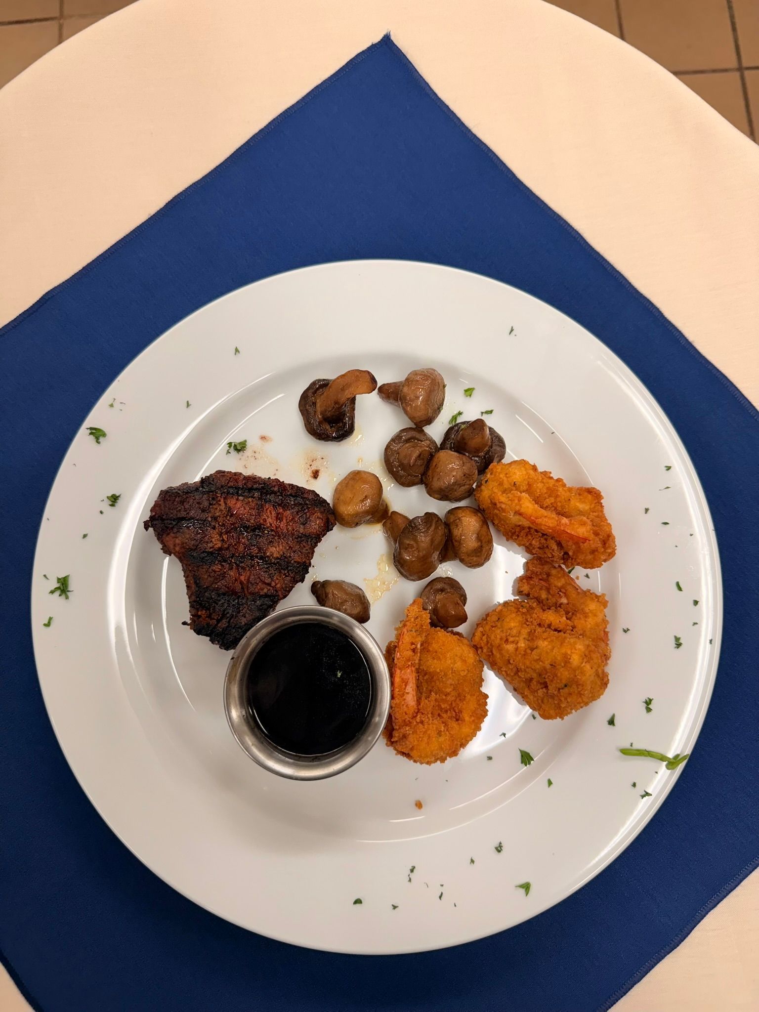 Appetizer plate with dark meat, fried shrimp, mushrooms, and dipping sauce.